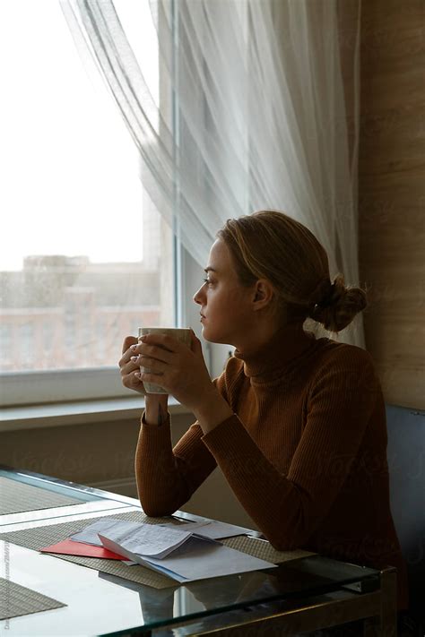 Pensive Young Female Employee Relaxing With Cup Of Coffee In Cafe By