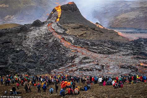 Sightseers Climb To The Edge Of Erupting Iceland Volcano As Lava Cascades Down Mountainside