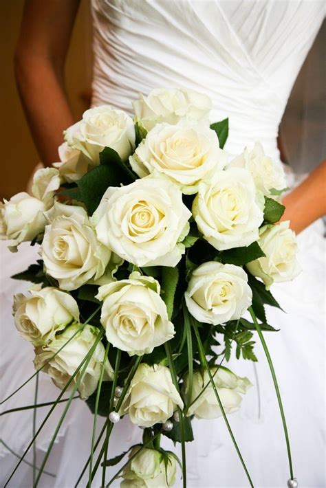 Close Up Of White Rose Bouquet Decorated With Pearl Beads In Brideâs