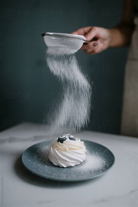 Woman Pouring Powdered Sugar On Cake By Stocksy Contributor Julia