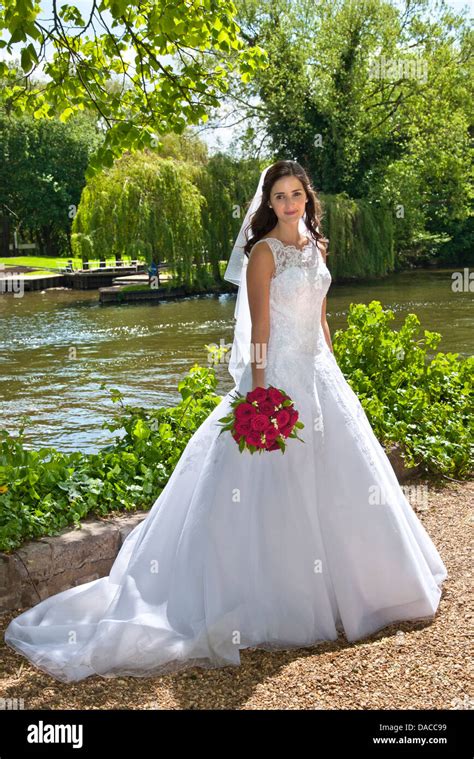 Bride In Traditional White Bridal Dress With Red Rose Bouquet Just