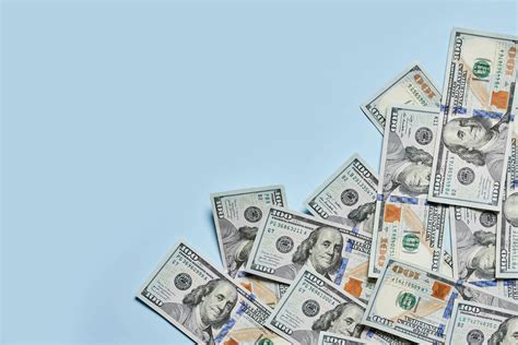Download A Hundred Dollar Bill With Vibrant Blue Hues Wallpaper