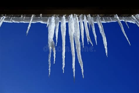 Icicles Hanging From Rooftop Of Home Melted Ice Dripping Stock Image
