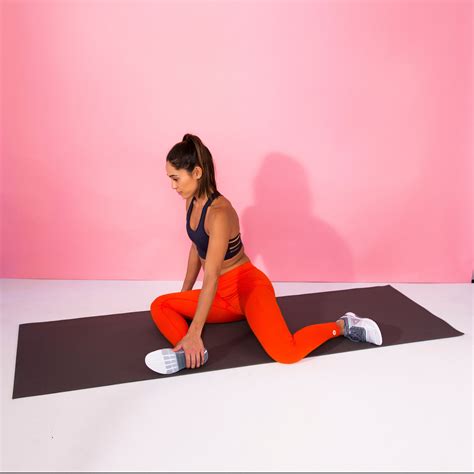 A Woman Sitting On A Yoga Mat In Front Of A Pink Wall
