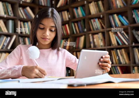 Concentrated Latin Schoolgirl Watching Online Learning Video At Home On