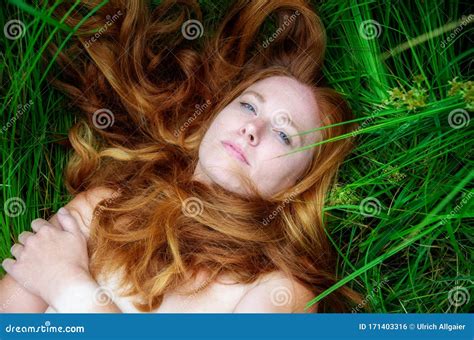 Portrait Of A Beautiful Red Haired Woman Lying In The Sun In Happiness