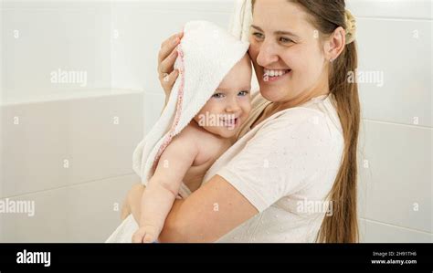 Portrait Of Smiling Mother Drying Her Cute Baby Babe With Bath Towel