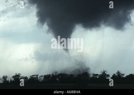 A Close Tornado Forms Beneath The Wall Cloud Of A Supercell Stock Photo