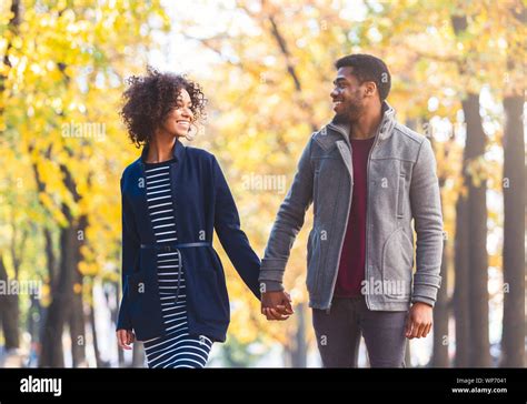 Black Couple Holding Hands While Walking By Autumn Park Stock Photo Alamy