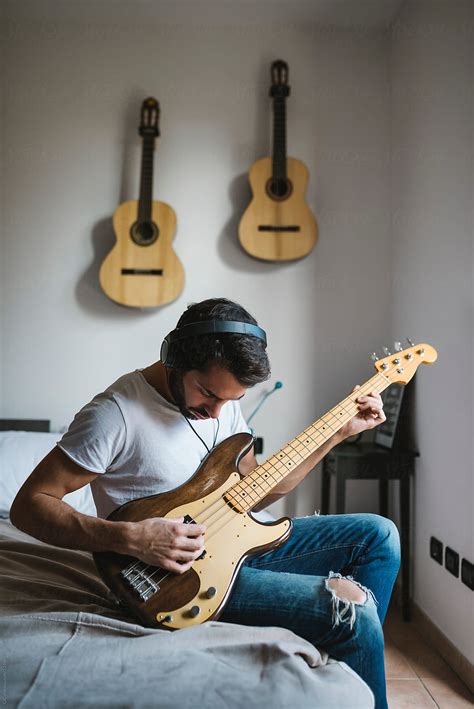 Man Playing Bass Guitar At Home By Stocksy Contributor Simone Wave