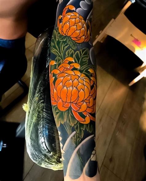 A Person With A Tattoo On Their Arm Is Holding A Fish And Some Orange