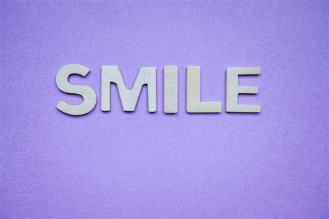 Premium Photo Smile Word With Wooden Letters On The Purple Background