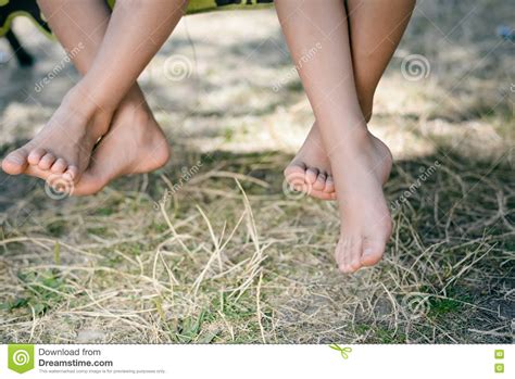 Outdoor Picture Of Two Children Legs Barefoot Closeup Of