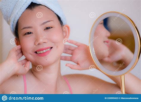 Young Beautiful And Happy Asian Chinese Woman With Towel Head Wrap Applying Makeup Looking To