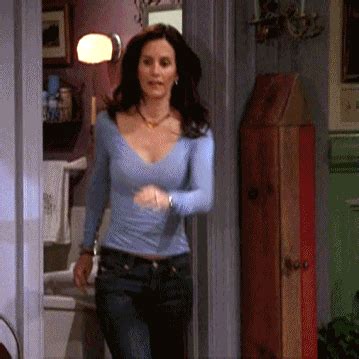 A Woman In Blue Shirt And Jeans Walking Into A Kitchen
