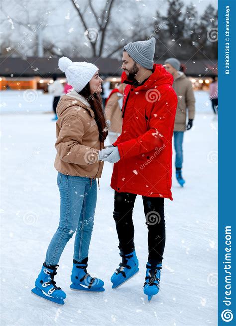 Feliz Pareja Joven Patinando En Pista De Hielo Al Aire Libre Imagen De