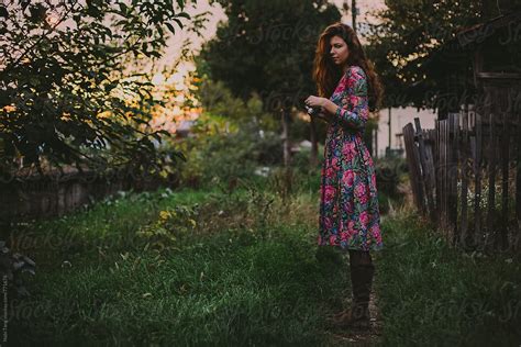 Beautiful Young Woman In Floral Dress With Camera In The Garden By Stocksy Contributor Nabi