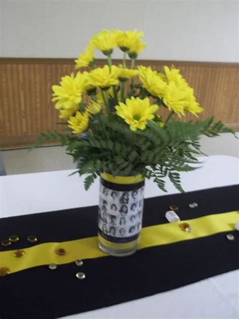 A Vase Filled With Yellow Flowers Sitting On Top Of A Black And White