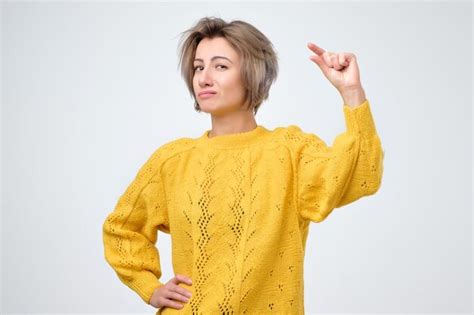 Mujer Que Muestra Una Pequeña Cantidad De Algo Con Los Dedos Foto Premium