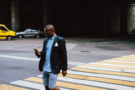 Black Man With Smartphone Crossing Road By Alina Hvostikova