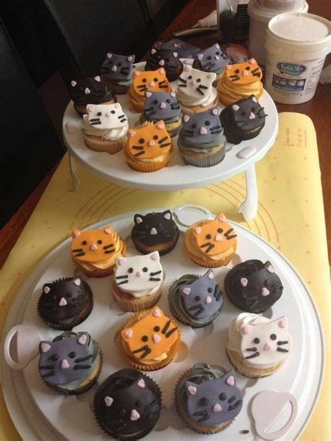 Two Tiered Trays Holding Cupcakes Decorated With Cats