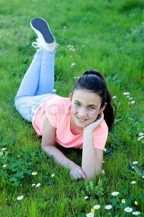 happy preteen girl lying in the grass stock image colourbox