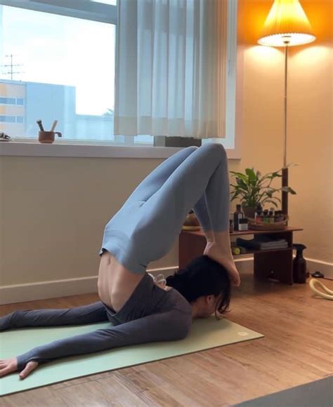 A Woman Is Doing Yoga On The Floor In Front Of A Window With Her Legs Up
