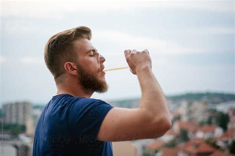 Young Man Drinking A Beer By Stocksy Contributor Boris Jovanovic