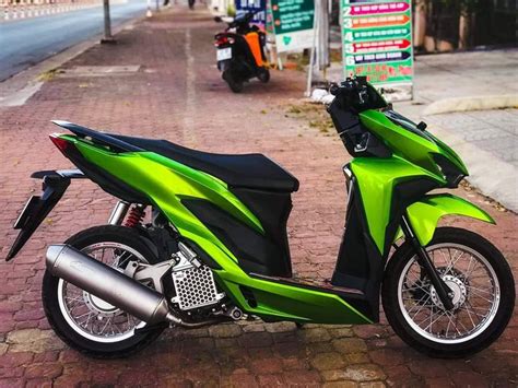 A Green And Black Motor Scooter Parked On The Street