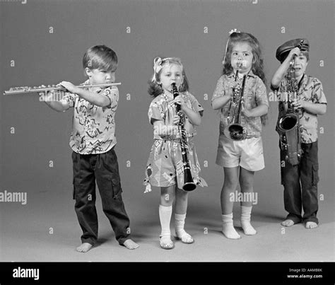 Two Boys And Two Girls Playing Flute Clarinet Trumpet And Saxophone