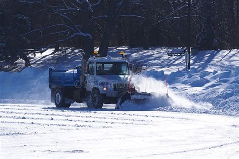 Snow Plow Truck Clearing Icy Road After Winter Snowstorm Blizzard For