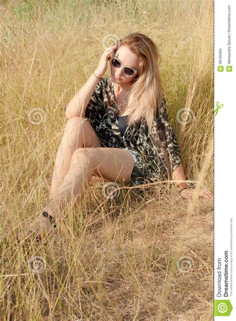Pretty Blond Girl Sitting On Field With Dry Grass Stock Photo Image