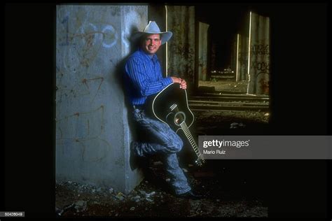 Cw Singer Garth Brooks Wearing Cowboy Hat And Holding Black Acoustic