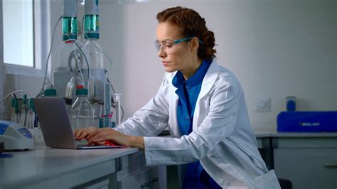 Female Scientist Working In Laboratory Lab Worker Typing Test Report