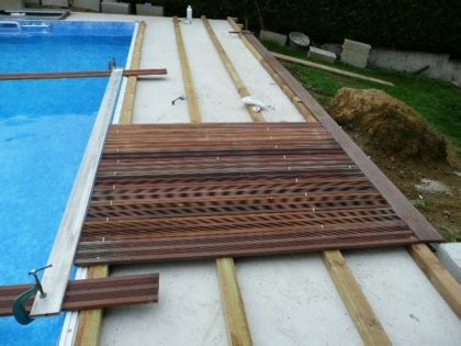 Mise en place de la double structure, fixée sur des vis de fondation. Pose terrasse bois autour de piscine - veranda-styledevie.fr