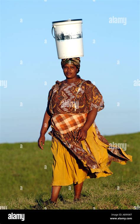 a xhosa woman carrying a bucket of water on her head in the eastern