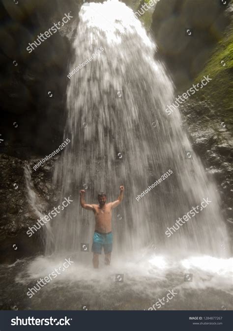 Man Standing Under Waterfall Stock Photo 1284877267 Shutterstock