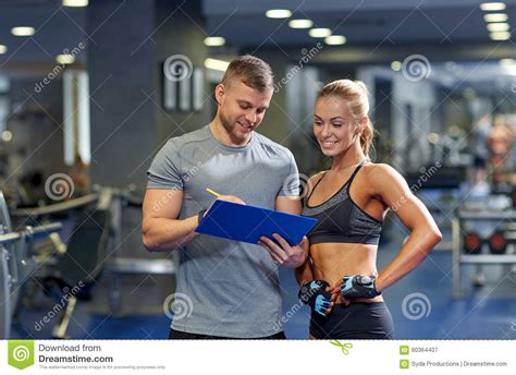 Smiling Young Woman With Personal Trainer In Gym Stock Image Image Of Healthy Happy 60364407
