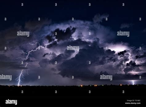Lightning Bolt In The Night Sky As A Thunderstorm Cumulonimbus Cloud