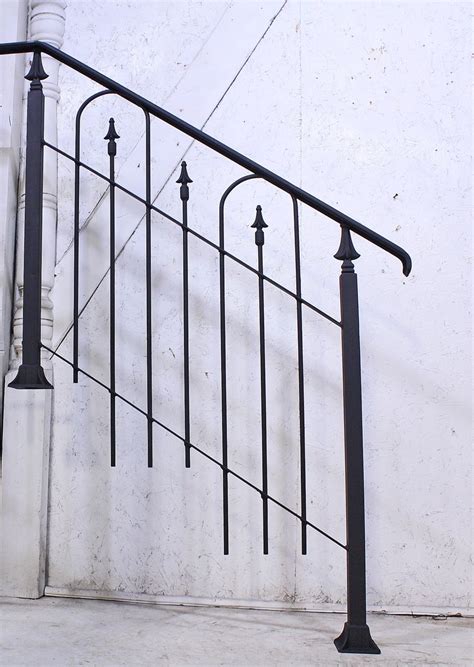 While keeping one rail post on the step (⇓), raise the other rail post off the mounting surface (⇑) until the level reads plumb. Stairway Hand Rail - Wrought Iron Railing 2 Steps