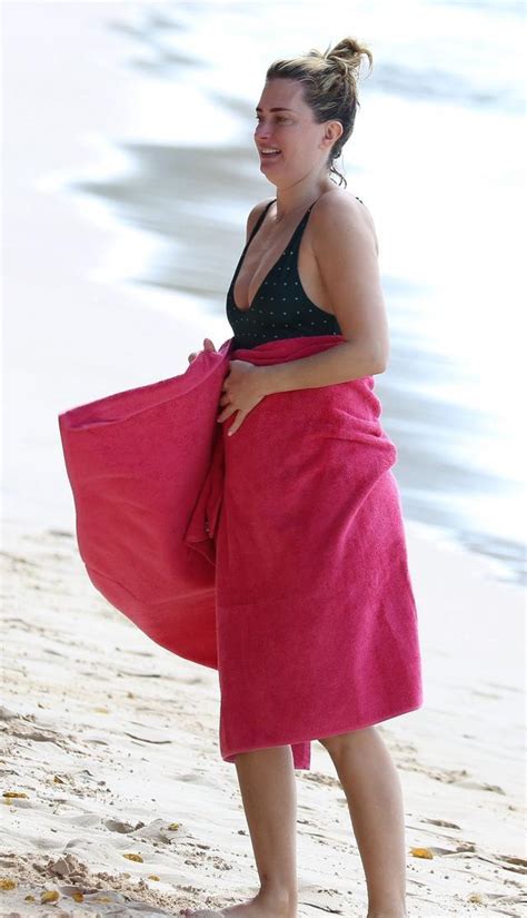 身着绿色泳装的丽亚·达勒姆rhea Durham在巴巴多斯海滩享受阳光