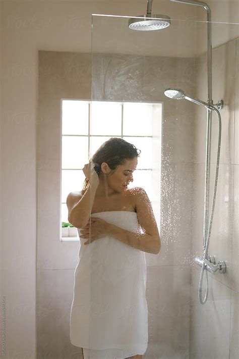 Young Woman In A Bathroom Wrapped In A White Towel After A Shower By