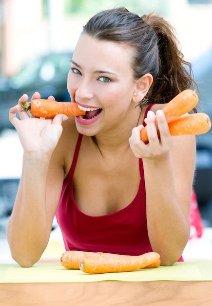 Free Photo Pretty Woman Eating Carrots At Home