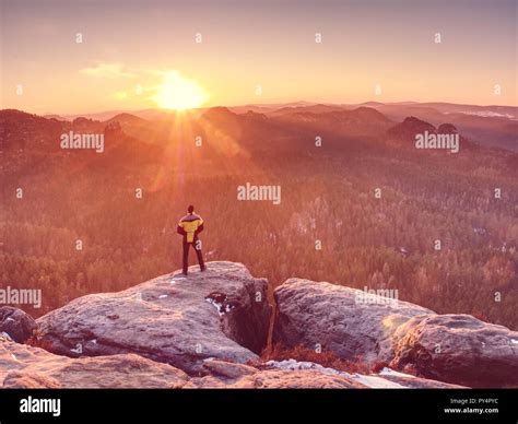 Man Standing At The Rocky Edge Young Man Watching Sunrise At Hilly