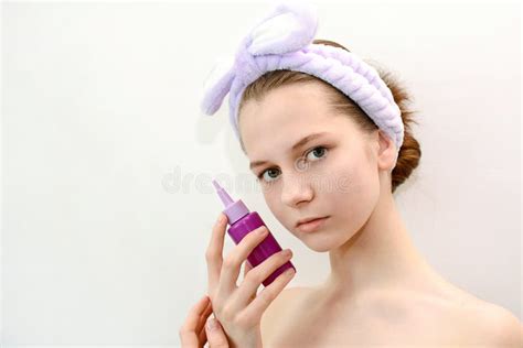 A Young Girl Holds A Bottle Of Beauty Care Products In Her Hands