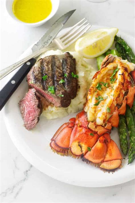 Well done style t bone steak and lobster plate on table beside roasted vegetables side dish and glass of water. Better Than Outback Grilled Steak and Lobster Dinner ...