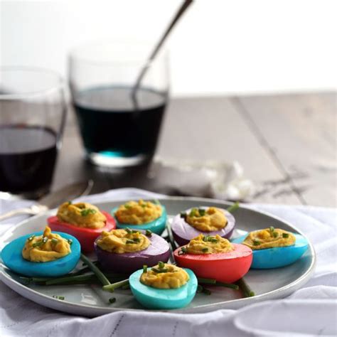 Small Colorful Deviled Eggs On A Plate Next To A Glass Of Red Wine And