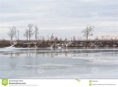 Frozen Melting Winter River Shore With Trees On The Other Side Stock