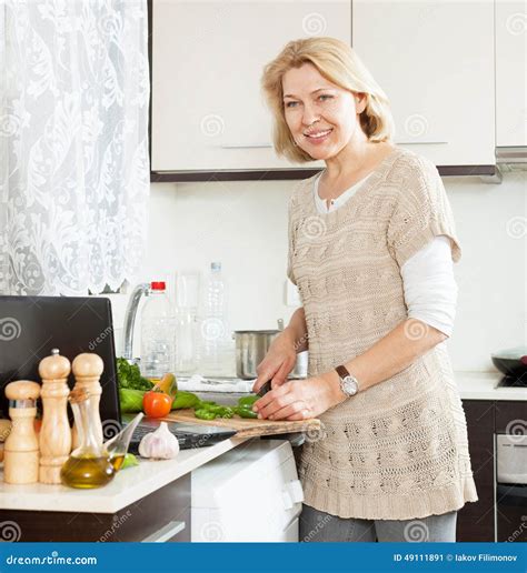 Smiling Woman Looking Recipe For Cooking In The Internet Stock Image
