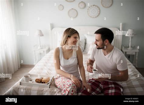 Picture Of Young Happy Couple Sitting On Bed Stock Photo Alamy